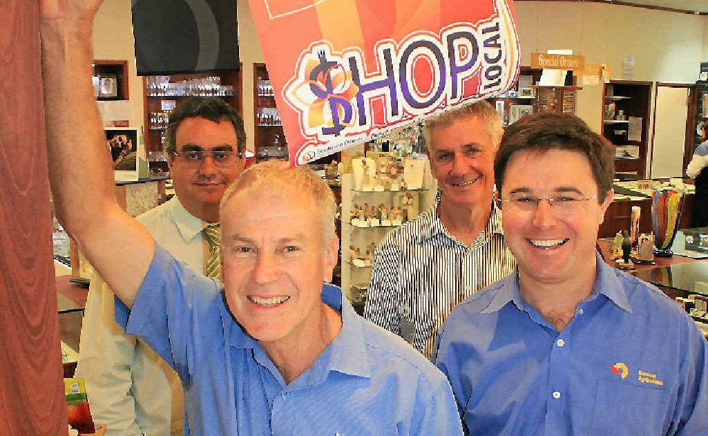 Jason Gard, John Randall, Dave Littleproud and (front) Peter Walsh put up the shop local banners.
